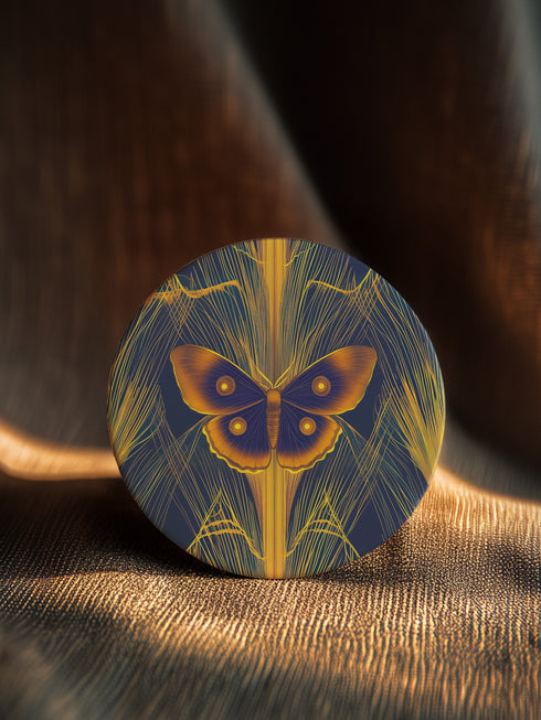 Round ceramic coaster featuring golden Luna moth illustration on dark green background with rose gold linear patterns. Cork-backed, 4-inch diameter. Perfect for vintage nature and gothic decor enthusiasts.